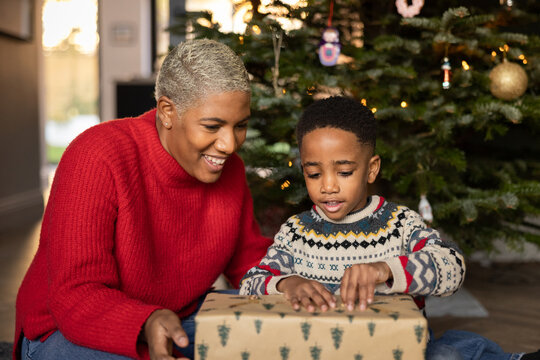 Mother and son together at Christmas time opening a present