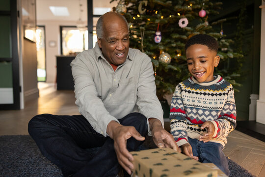 Grandfather giving grandson a gift at Christmas present