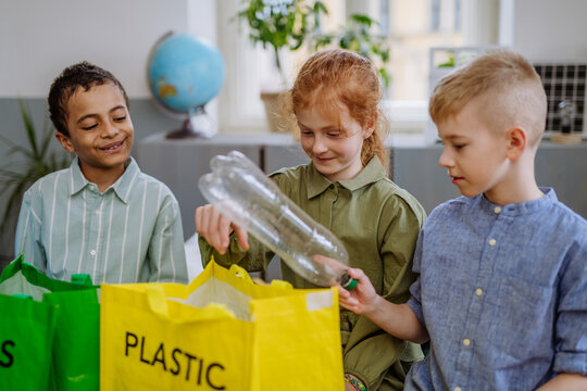 Children separating rubish in to three bins.