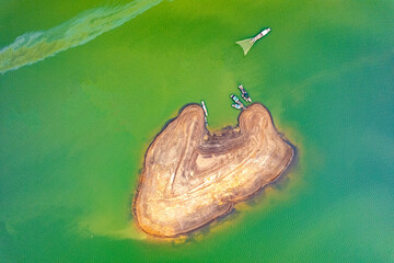 Tri An lake, Dong Nai province, Vietnam in the green algae season has a beautiful green color. Fishing boats come ashore