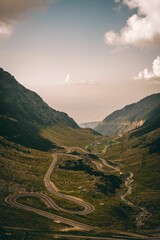 scenic mountain landscape with winding road below cloudy sky, viewed from viewpoint