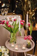 Decoration tulips flowers, decor candles. Candlelight dinner setup table for couple on Valentine's day. Table setting in the restaurant. Luxury romantic date. Location for surprise marriage proposal.