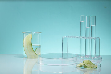 Transparent podium displayed with test tubes, beaker and glass petri dish containing Cucumber...