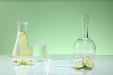 Lab glassware and cucumber slices on blue background. Space for display cosmetic of cucumber extract, which is frequently used in the creation of natural cosmetics, is safe for all skin types