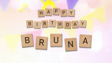 Happy Birthday Bruna card with wooden tiles text. Girls birthday card with colorful background.
