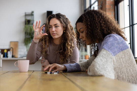 Female friends looking at healing crystals together