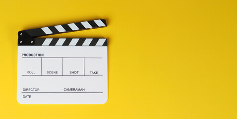 Naklejka premium Clapper board or white movie slate on yellow background.
