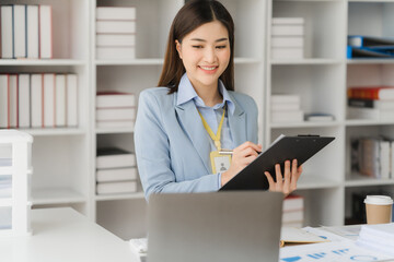 Asian businesswoman in formal suit in office happy and cheerful during using smartphone and working