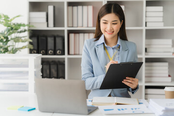 Asian businesswoman in formal suit in office happy and cheerful during using smartphone and working