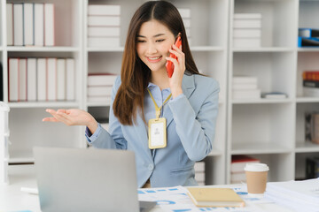 Asian businesswoman in formal suit in office happy and cheerful during using smartphone and working