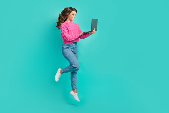 Full length photo of positive cheerful adorable lady use netbook fast 4g connection empty space isolated on cyan color background