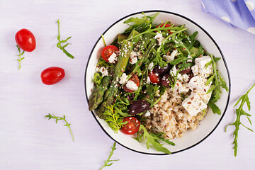 Breakfast oatmeal porridge with feta cheese, cherry tomatoes, asparagus and arugula. Healthy balanced food. Top view, overhead