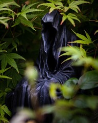 Close-up image of a tall, menacing statue depicting the Grim Reaper, wearing a black robe