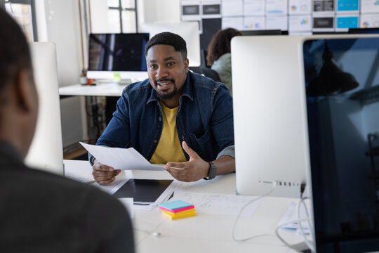 Coworkers having an informal meeting at their desks