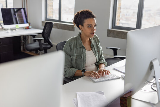 Pregnant businesswoman working at a desktop computer in an office