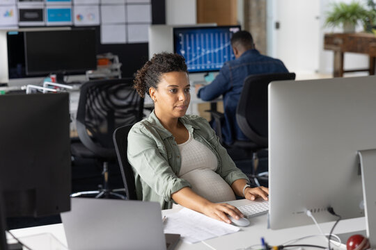 Pregnant businesswoman working at a desktop computer in an office