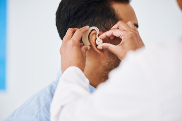 Doctor, man and hearing aid on ear for medical support, wellness and innovation of disability....