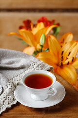 Porcelain cup with tea on a wooden table.
