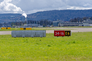 Red sign at runway at Swiss Airport Zürich Kloten on a sunny spring morning. Photo taken April...