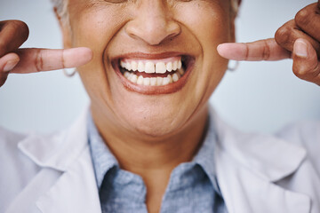 Dental, hand and pointing by elderly woman in studio for mouth, hygiene or denture care on grey background. Teeth whitening, cleaning and senior lady happy for oral, tooth and natural looking veneers