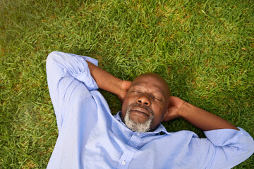 Overhead Shot Of Senior Man Sleeping On Grass Outdoors In Garden At Home