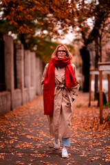 Confident woman wearing scarf and trench coat while walking alone on street