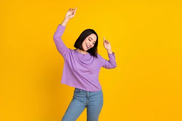 Vlies Fototapete Musikladen Photo of young carefree relaxed woman dancing fingers point up empty space new brand outlet store ad isolated on yellow color background