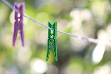 Green clothes peg on white clothesline.