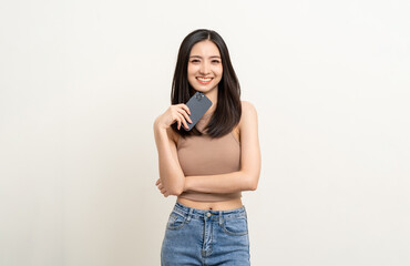 Pretty young asian woman using smartphone standing on isolated white background. Excited Beautiful young asian shopping online payment with mobile phone. Playing game on smartphone