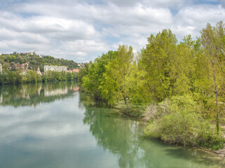 View from Woodrow Wilson bridge over Rhone river, in Lyon, France, looking north, showing woods of park of the Brétillod 