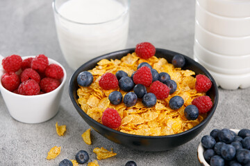 Tasty cereal with blueberries and raspberries on grey table