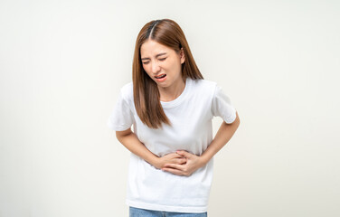 A woman had a stomach ache and gastritis. She put her hand on her stomach and squeezed it to relax and soothe. She is 25 years old and has menstrual cramps. Shot on isolated white background.