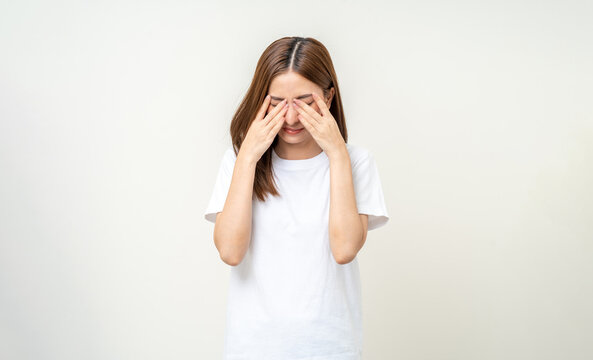 Young asian beautiful woman hand rubbing eyes she's feeling depressed stress headache be tired from working standing on isolated white background she has health problems.