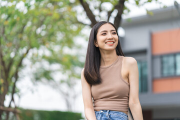 Fototapeta premium Happy feeling of Beautiful Young Woman smiling outdoor in sunlight. Pretty attractive face of female and beautiful smile. She is positive thinking and successful.