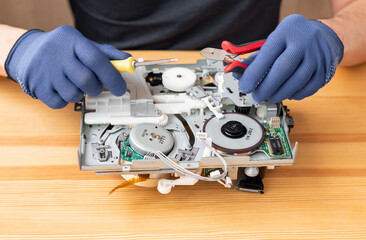 a man repairs and solders microcircuits for household appliances
