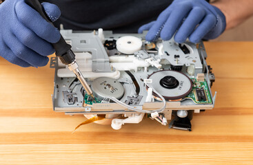 a man repairs and solders microcircuits for household appliances