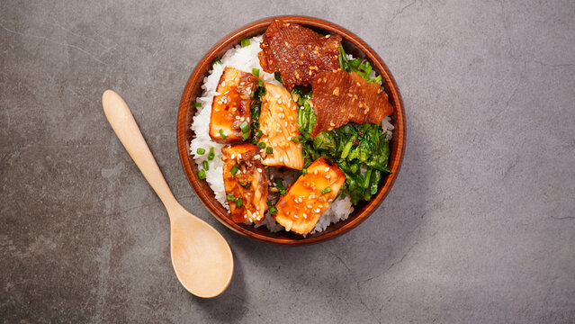 Grilled salmon (toriyaki sauce) and stir-fried vegetables in a brown wooden bowl.