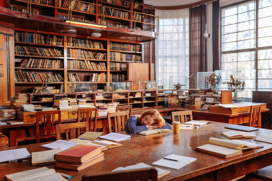 Tired student sleeping in library