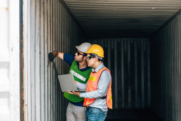 Team Engineer and worker wear safety uniform check control loading freight cargo container use computer laptop at commercial dock warehouse,transportation import,export logistic industrial service