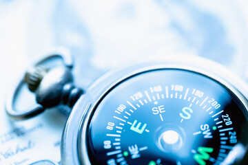 Compass against one hundred US Dollar bill background as symbol of moving in the right direction in...