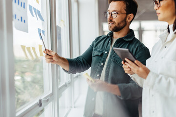 Creative business people brainstorming with sticky notes in an office