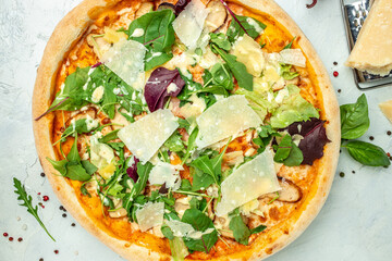 Delicious pizza Caesar with chicken, cheese and lettuce. on a light background. Restaurant menu, dieting, cookbook recipe top view