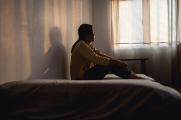 Silhouette photo of young Asian woman feeling upset, sad, unhappy or disappoint crying lonely in...