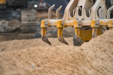 Rear scarifier tines of a grader working in sand