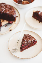 Delicious chocolate cake brownie with cherries on white wooden table