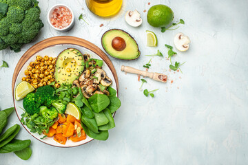 healthy vegan lunch bowl with Avocado, mushrooms, broccoli, spinach, chickpeas, pumpkin on a light background. vegetables salad. Top view