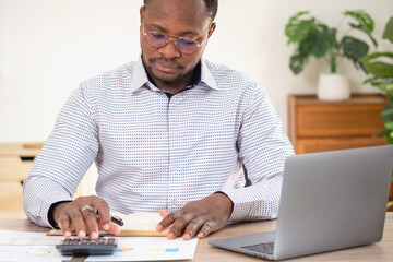 African black businessman sitting doing a financial report and studying annual profit analysis An accountant checking the financial status of the company is in the office.