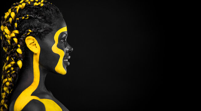 The Art Face. Download High Resolution Picture with Black and yellow body paint on african woman. Create Album Template with Creative Image. Copy space for your text