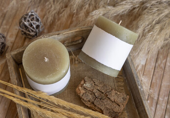 Candles with blank label near natural wooden decorations, Close up, copy space, mock up