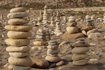 Fototapeta na wymiar Stone towers stacked with stones on a Cypriot beach
